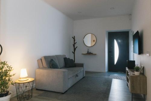 a living room with a couch and a mirror at Central Charm Azores in Ribeira Grande