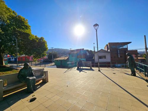 two people sitting on a bench in a park at Hostal Florida Valpo in Valparaíso