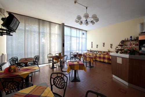 un ristorante con tavoli e sedie e una sala da pranzo di Hotel Roma a Cassano Magnago