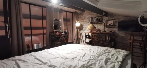 une chambre avec un lit blanc et un mur de briques dans l'établissement Superbe Villa tout confort avec piscine, à Beaucaire