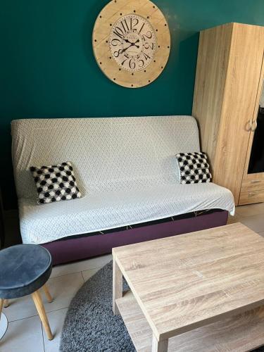 - un canapé dans le salon doté d'une horloge murale dans l'établissement Harmonie, à Aulnay-sous-Bois