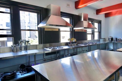 a large kitchen with stainless steel counters and windows at Ritz For Backpackers in Melbourne