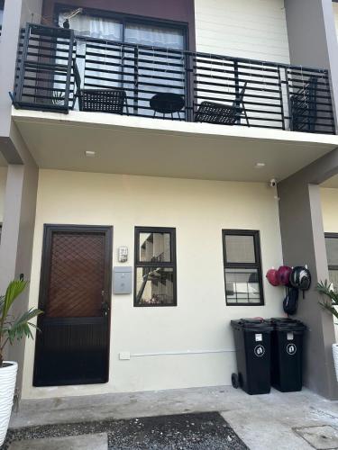 a house with a balcony and a black door at Casa Bella in Baclayon
