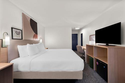 a hotel room with a bed and a flat screen tv at Spark by Hilton Norfolk in Norfolk