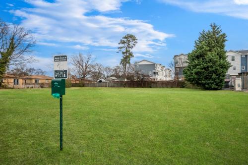 a sign in the middle of a field with houses at Spark by Hilton Norfolk in Norfolk
