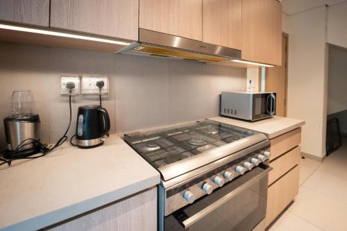a kitchen with a stove and a microwave at White Villa By the Sea in Fujairah