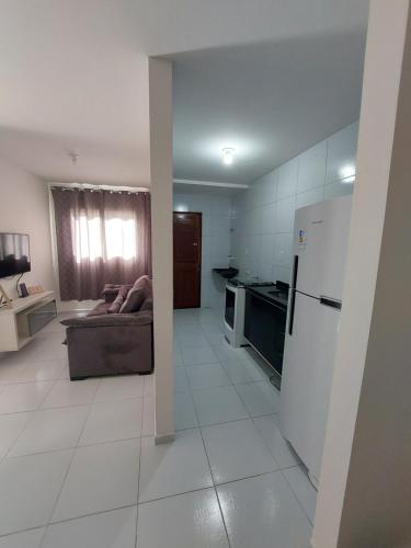 a kitchen and living room with a couch and a refrigerator at Nosso lar in Campina Grande