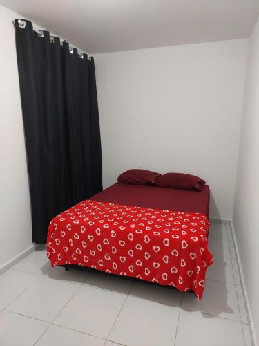 a red bed in a room with black curtains at Nosso lar in Campina Grande