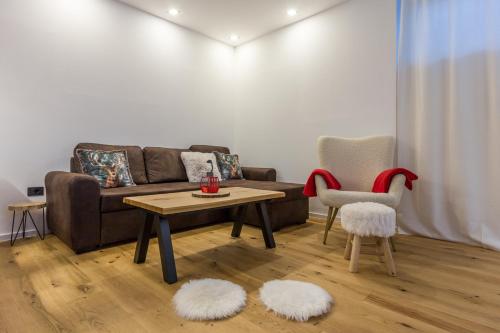 a living room with a couch and a table and two chairs at Charming A&S Pohorje Apartments in Pohorje
