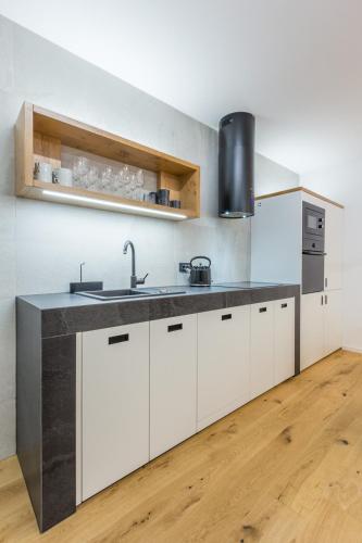 a kitchen with white cabinets and a sink at Charming A&S Pohorje Apartments in Pohorje