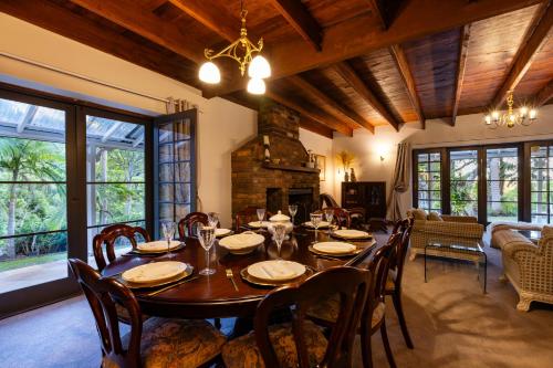 a dining room with a table with chairs and a fireplace at Grande Eden Estate - Main House in Bilambil