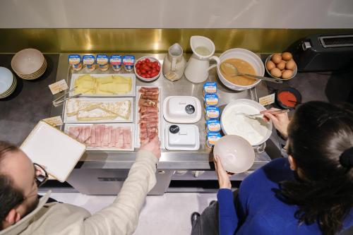 a group of people preparing food in a kitchen at Hôtel du Parc Thionville Centre in Thionville
