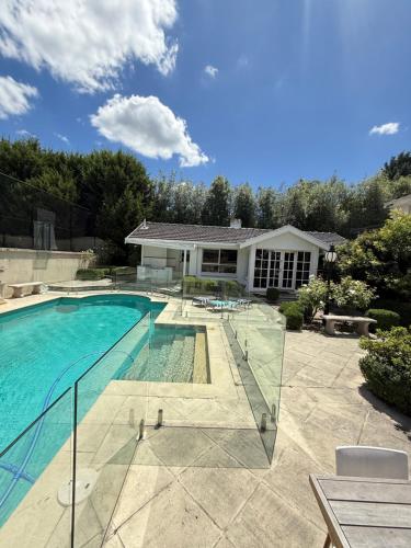 a swimming pool in front of a house at Stunning White House Luxury Retreat In Templestowe in Templestowe