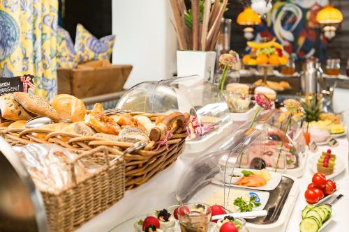 a buffet with bread and other foods on a table at Hotel Alpenhof Postillion in Kochel