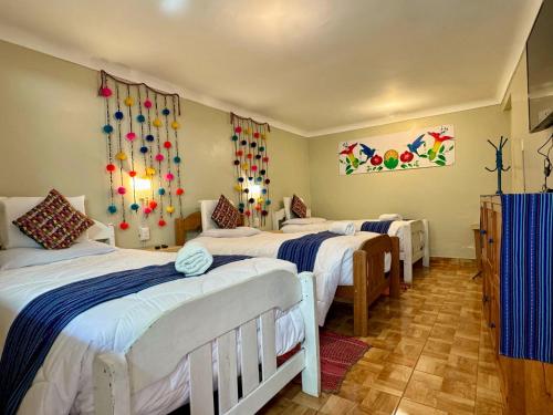 a group of four beds in a room at Tika house in Cusco