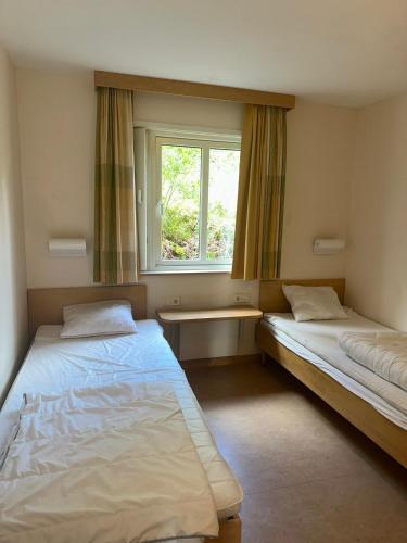 two beds in a room with a window at Resort Yxenhaga in Hok