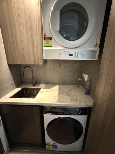 a small kitchen with a microwave and a sink at The Atrium - Olympic Park 50m to ACCOR FREE PARK in Sydney
