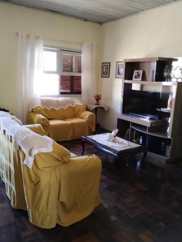 a living room with a couch and a tv at Hospedagem in São Gabriel