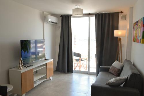 a living room with a couch and a television at Departamento Buena Vista in Leones