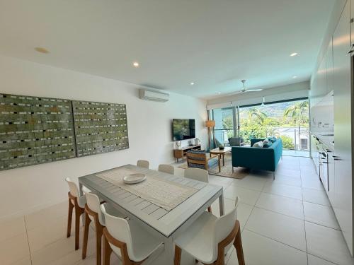 a dining room and living room with a table and chairs at Pool Resort Port Douglas in Port Douglas