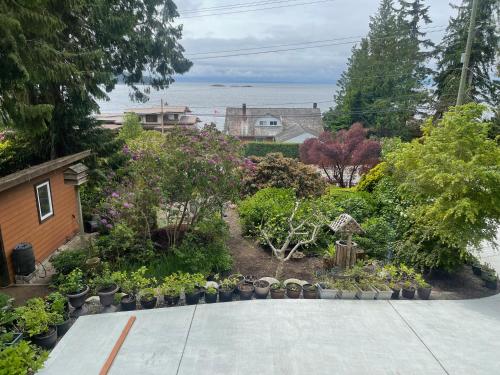a garden with flowers and plants in front of a house at Garden Bridge House in Sechelt