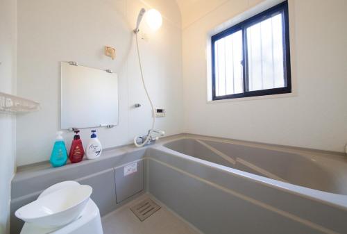 a bathroom with a tub and a toilet and a sink at 10 min walk to the beach Kujukuri house for 14 ppl in Hasunuma
