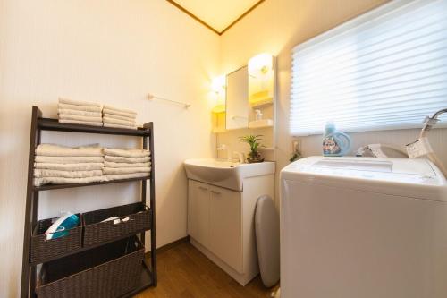 a small bathroom with a sink and a washing machine at 10 min walk to the beach Kujukuri house for 14 ppl in Hasunuma