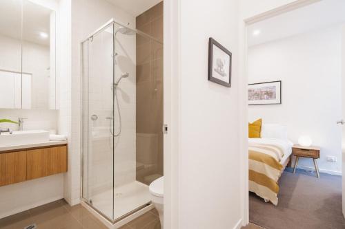 une salle de bain avec douche et toilettes et un lit dans l'établissement StayCentral - Brunswick Boutique, à Melbourne