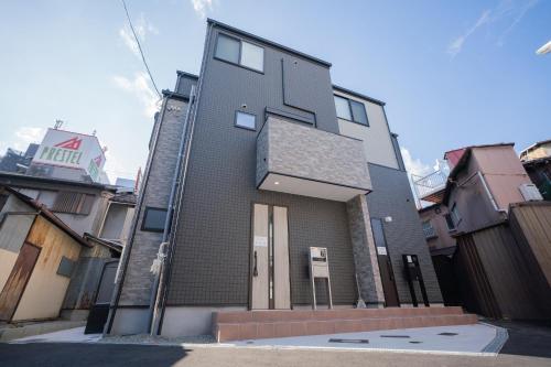 a tall building with a sign on the side of it at CASAS-K Teradacho in Osaka