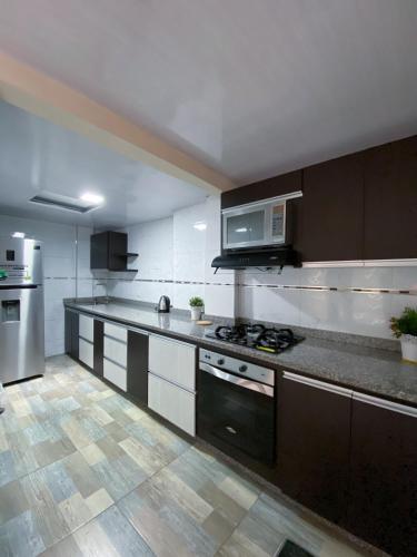 una grande cucina con piano cottura e forno a microonde di Apartamento en Santa Rosa de Cabal a Santa Rosa de Cabal