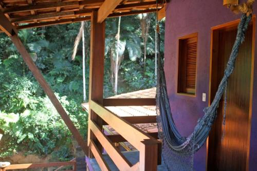 a hammock hanging from the side of a house at Pousada O Canto das Sereias in Trindade