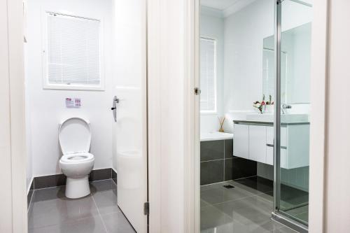 a bathroom with a toilet and a sink at Standard Queen Room in Gregory Hills - Quaint Spot - Shared Bathroom in Gledswood Hills