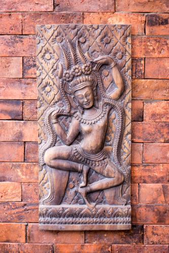 a stone statue of a woman on a brick wall at Khmer Paradise Villa in Siem Reap