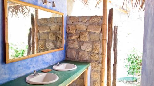 a bathroom with two sinks and a mirror at Kasa Pelikanos in Vichayito