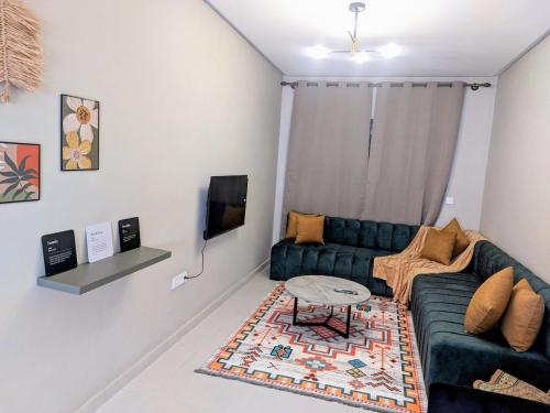 a living room with a couch and a table at Green Haven Near Airport Stay in Deroua