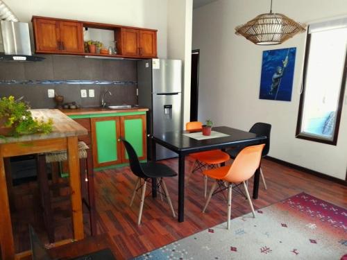 une cuisine avec une table noire et des chaises orange dans l'établissement Connection to Nature, à Estación Costa Azul