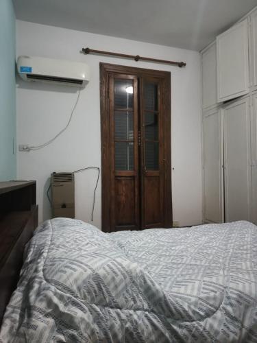 een slaapkamer met een bed en een houten deur bij Casita Verde in Rosario