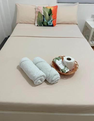 a bed with two towels and a basket on it at Villa Darroca Palawan in Araceli