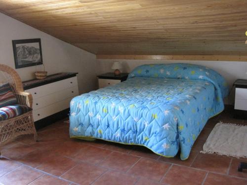 a bedroom with a bed with a blue comforter at Casa de piedra en el Valle de Lozoya in Canencia