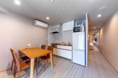 a kitchen and dining room with a table and a refrigerator at Kyoto Takatsuji Rose Heights in Kyoto