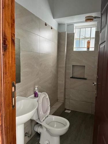 a bathroom with a toilet and a sink at Zoe Homes Greypoint 1 bedroom apartment 301 in Kericho