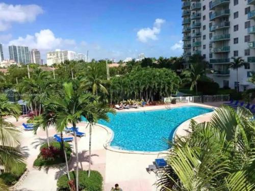 a pool at a resort with palm trees and buildings at Condominium Sunny Isles Ocean Reserve in Sunny Isles Beach