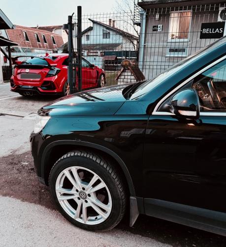 a black car parked in a parking lot at Bellas apartmani in Novi Sad