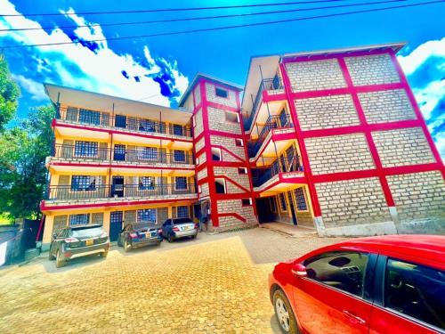 a red car parked in front of a building at Zoe Homes Oak Villa Apartment 1 and 2 Bedroom 201 in Kericho