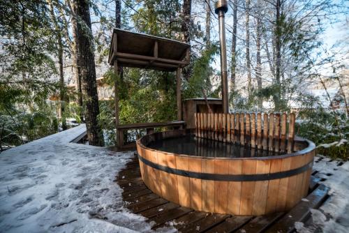 a hot tub in the snow with a wooden fence at Refugios Australes en Corralco in Malalcahuello