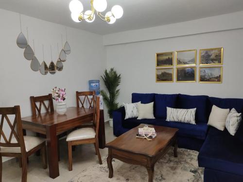 a living room with a blue couch and a table at Zoe Homes Oak Villa Apartment 1 and 2 Bedroom 201 in Kericho