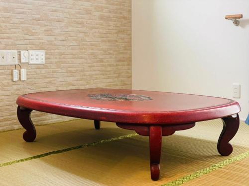 a red table sitting on the floor in a room at 空港まで車で15分ビーチまで徒歩1分海沿いの閒雲斎 in Itoman