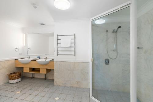 un bagno con doccia e lavandino di Absolute Beachfront One Bedroom Alassio Apartment 201 Palm Cove a Palm Cove