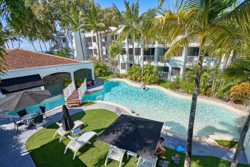 una vista dall'alto di una piscina con palme di Absolute Beachfront One Bedroom Alassio Apartment 201 Palm Cove a Palm Cove