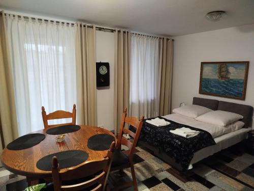a room with a table and a bed and a table and chairs at Apartament Włoski Styl in Gniezno